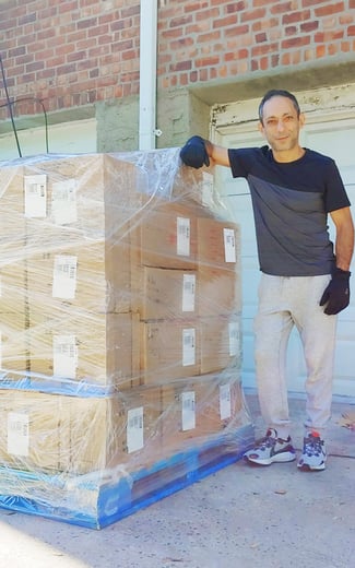 Essam Gawish with boxes on a pallet